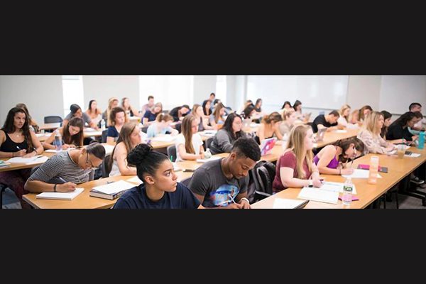 A multi-ethnic group of students listen in lecture